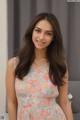 A woman in a floral dress posing for a picture.