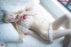 A woman laying on a bed in a white and red lingerie.