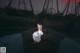 A woman in a white dress sitting on a boat.