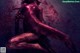 A naked woman with blood splattered on her body.
