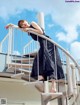 A woman in a black dress standing on a set of stairs.