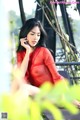 A woman in a red dress sitting on a bench.