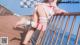 A woman in a pink and white outfit is posing on a pier.