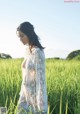 A woman standing in a field of tall grass.