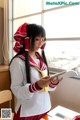 A woman in a school uniform is reading a book.