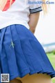 A woman in a school uniform with a grasshopper on her back.