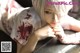 A woman with white hair and blood on her arm.