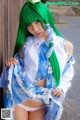 A woman with green hair wearing a blue and white outfit.