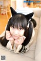 A woman with long black hair wearing a cat ears headband.