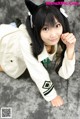 A woman in a white jacket and black cat ears.