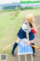 A woman in a school uniform holding a baseball bat.