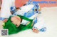 A woman with green hair laying on a white rug.