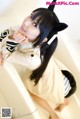 A woman in a cat costume sitting in a bathtub.