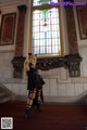 A woman standing in front of a stained glass window.
