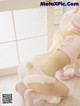 A woman in a pink bunny costume crouching on the floor.