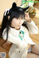 A woman in a white shirt and blue panties posing for a picture.