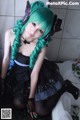 A woman with green hair sitting on a bathtub.