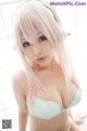 A woman with long pink hair wearing headphones.