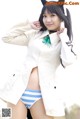 A woman in a white coat and blue and white striped panties.