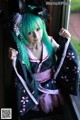A woman with green hair wearing a black and pink kimono.