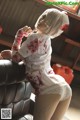 A woman dressed as a nurse with blood on her body.