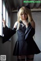 A woman in a black dress and cat ears posing for a picture.