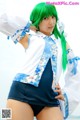 A woman with green hair wearing a blue and white shirt.