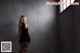 A woman in a black dress standing in a room.