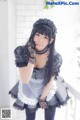 A woman dressed in a maid outfit posing for a picture.
