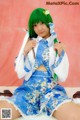 A woman in a blue and white dress holding a knife.