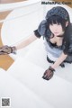 A woman in a maid outfit is posing for a picture.