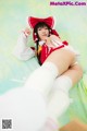 A woman in a red and white outfit laying on a bed.