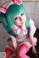 A woman in a pink and green nurse outfit posing for a picture.
