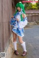 A woman with green hair wearing a blue and white dress.