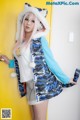 A woman with pink hair wearing a blue and white jacket.
