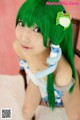 A woman with green hair holding a stuffed animal.
