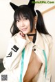 A woman in a white coat with a cat ears on her head.