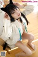 A woman in a white shirt and black cat ears sitting on a chair.