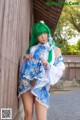 A woman with green hair wearing a blue and white dress.