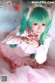 A woman with green hair wearing a pink dress.