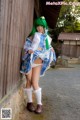 A woman with green hair wearing a blue and white outfit.