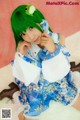 A woman with green hair wearing a blue and white dress.