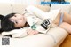 A woman laying on top of a white couch.