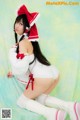 A woman in a white and red outfit is posing for a picture.