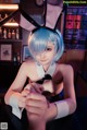 A woman in bunny ears sitting at a bar.