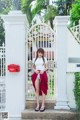 A woman standing in front of a white gate.