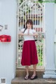 A woman standing in front of a white gate.