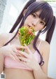 A woman in a pink bikini holding a bunch of flowers.