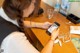 A woman sitting at a table using a cell phone.