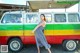 A woman standing in front of a colorful van.